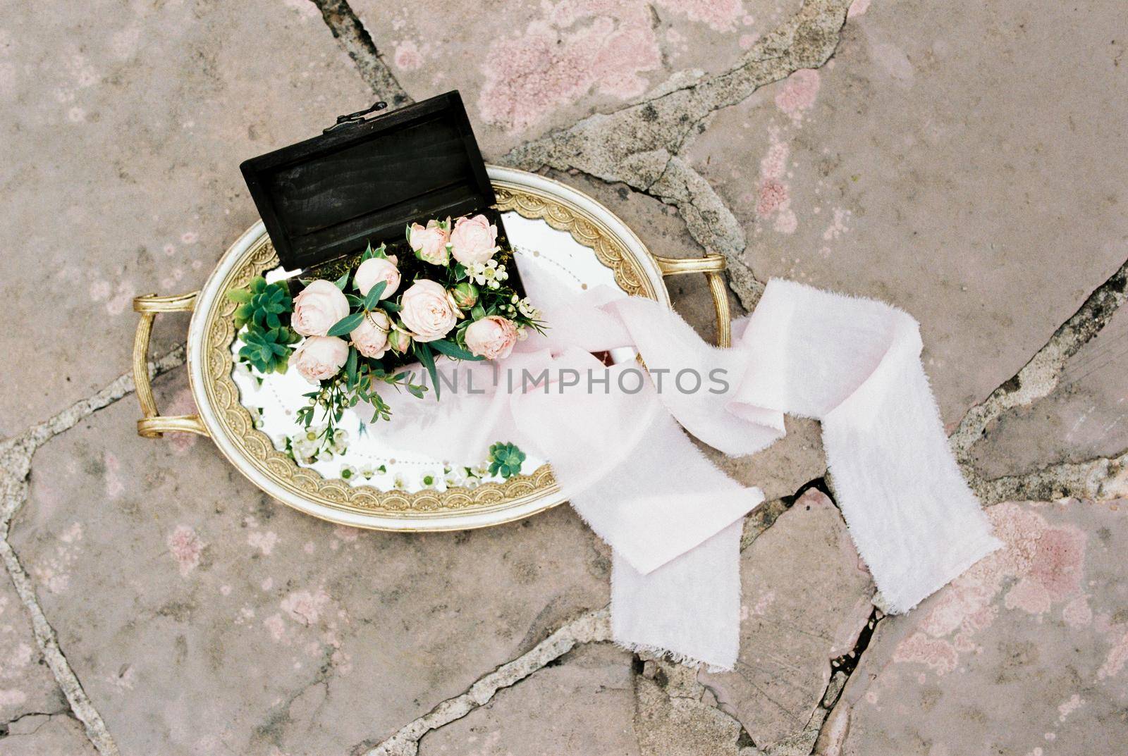 Tray with roses lies on a tile on the floor. High quality photo