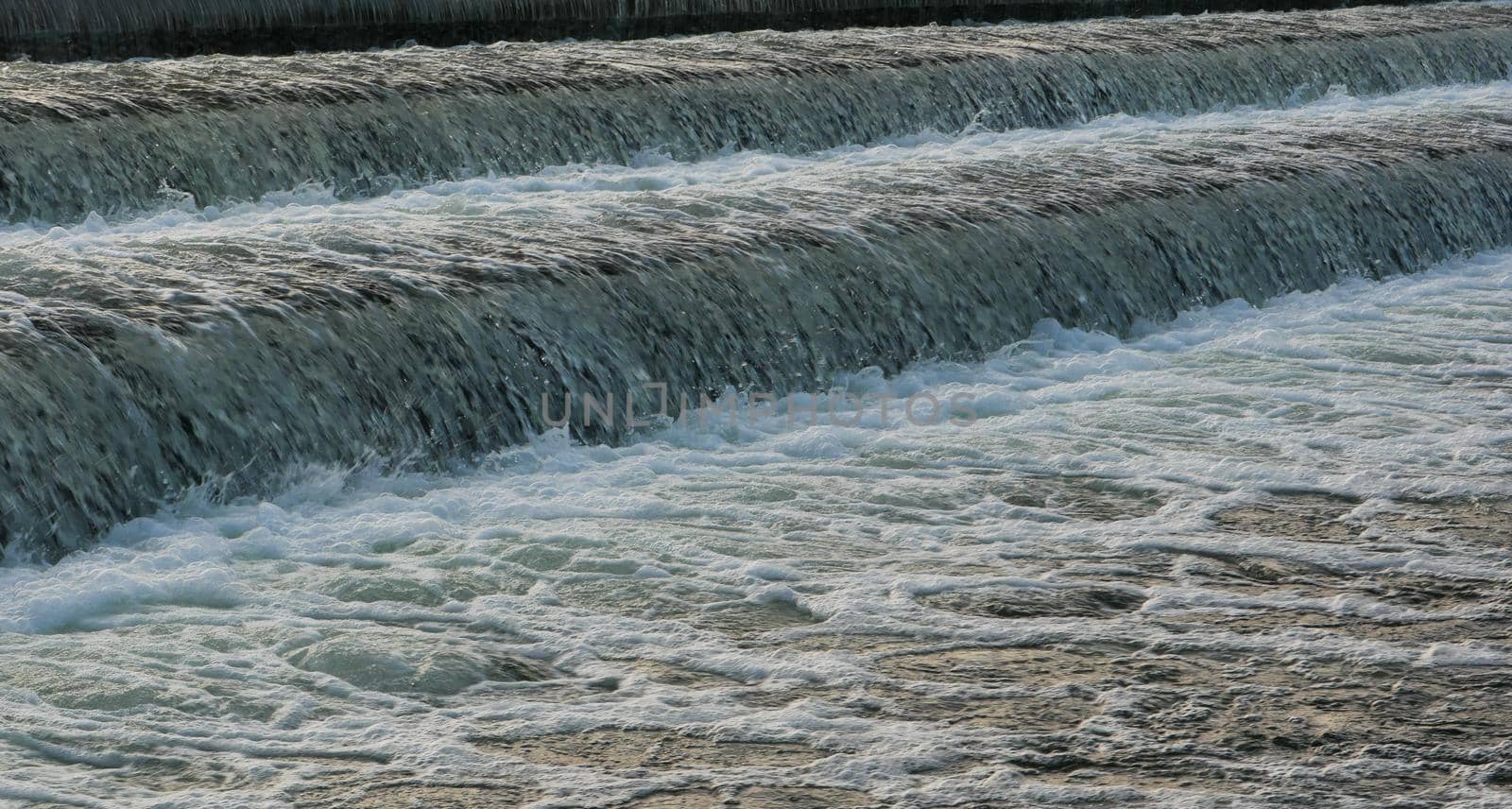 The water flows quickly through the rapid cascade of the river.