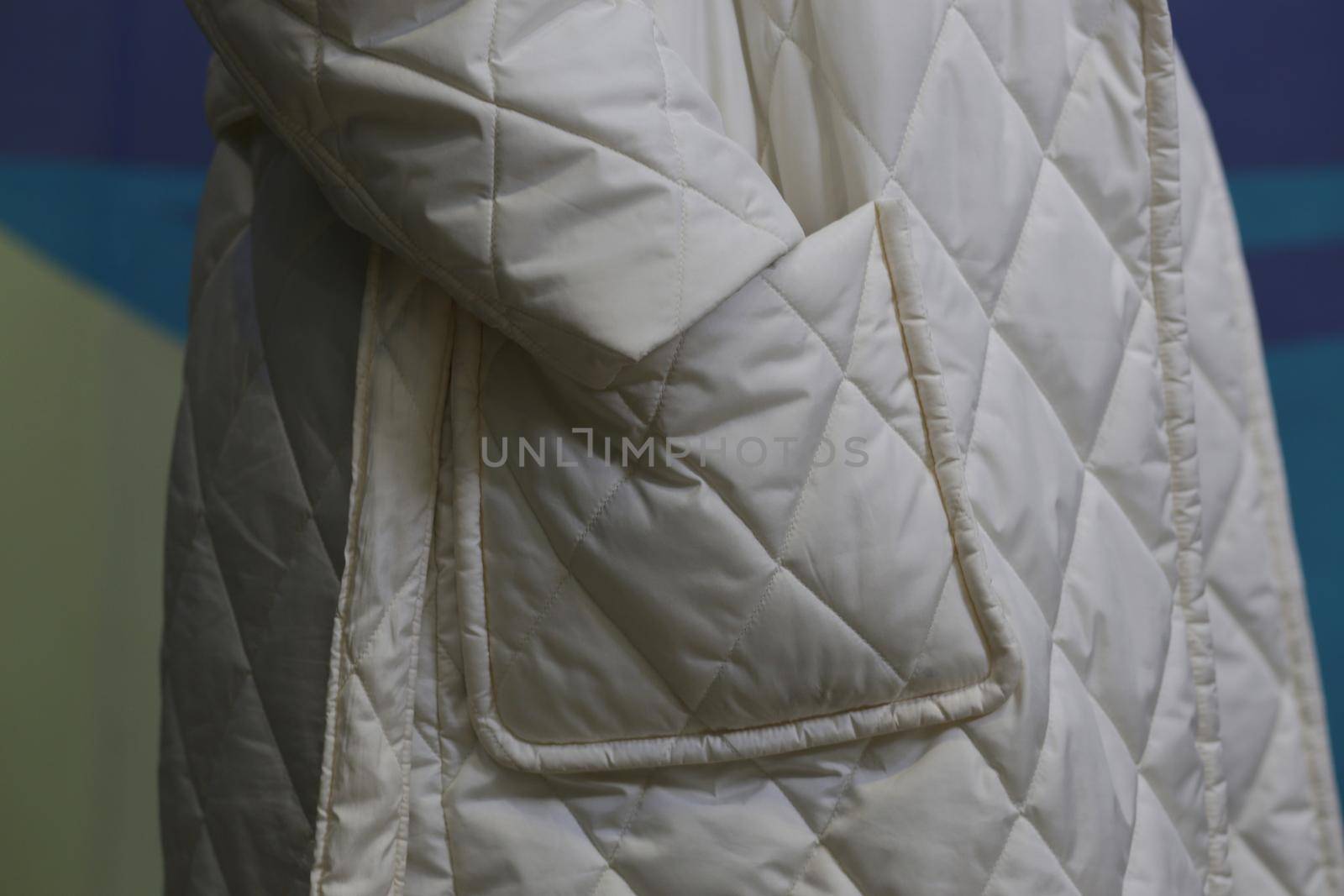 Close-up of white waterproof clothing material. Sleeve and pocket of a winter white coat close-up.