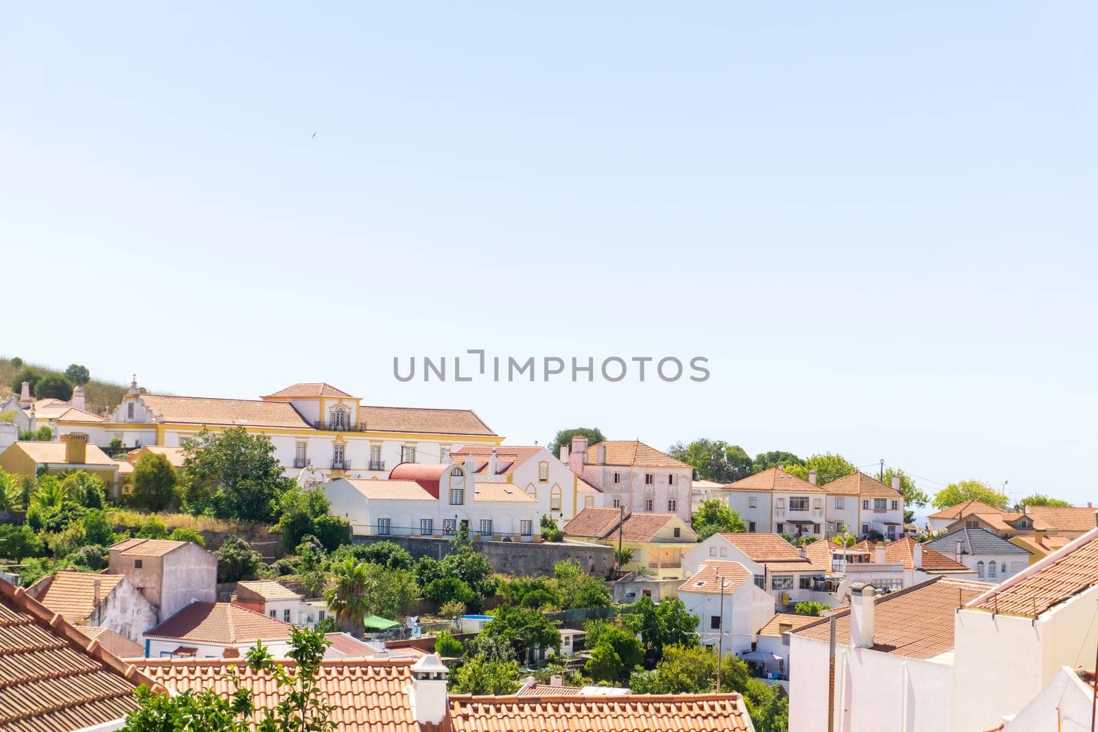 View of white houses with red tiled roofs in a Portuguese town on a sunny day