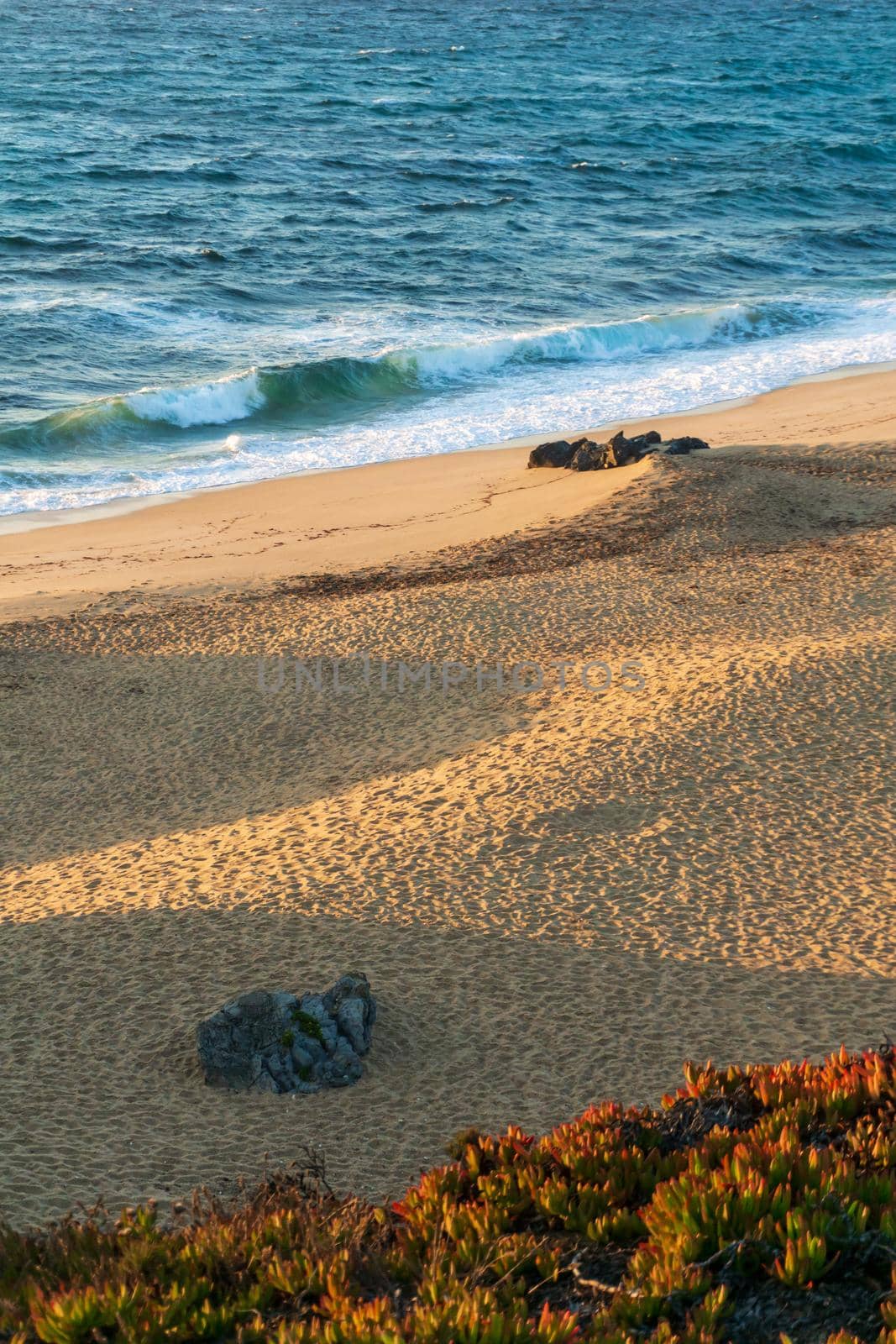 Deserted sandy beach of the atlantic ocean in the rays of the setting sun top view