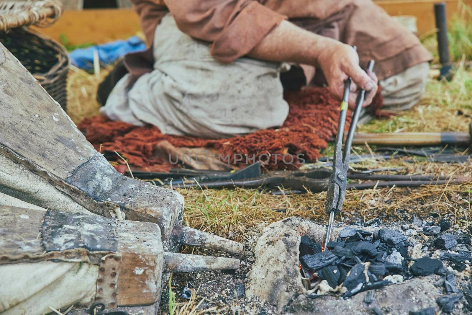 The blacksmith warms up the workpiece with bellows at viking festival in Denmark