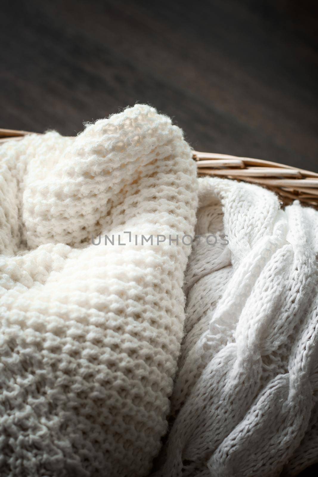 Knitwear, fabric textures and rustic lifestyle concept - Knitted winter clothes in a basket