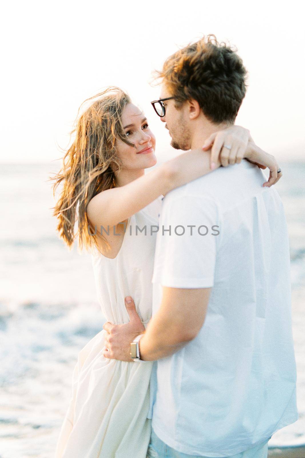 Man hugs woman by the waist and looks into her eyes. Portrait. High quality photo