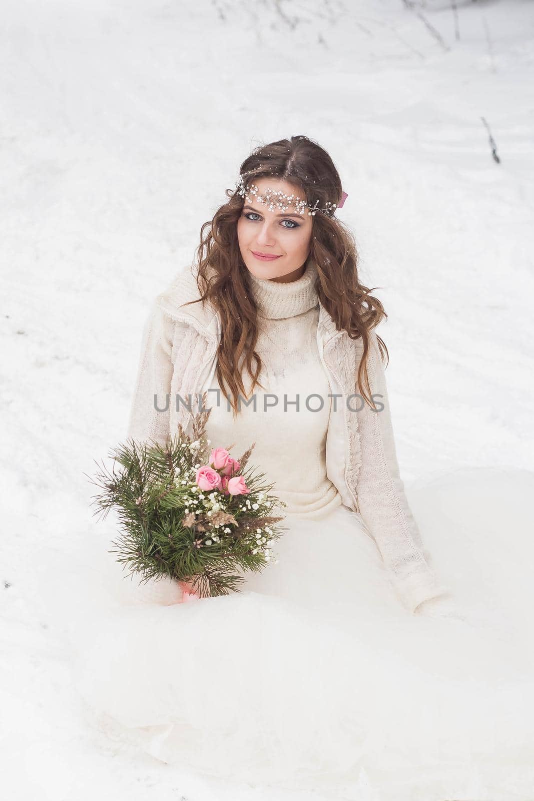 Beautiful bride in a white dress with a bouquet in a snow-covered winter forest. Portrait of the bride in nature. by Annu1tochka