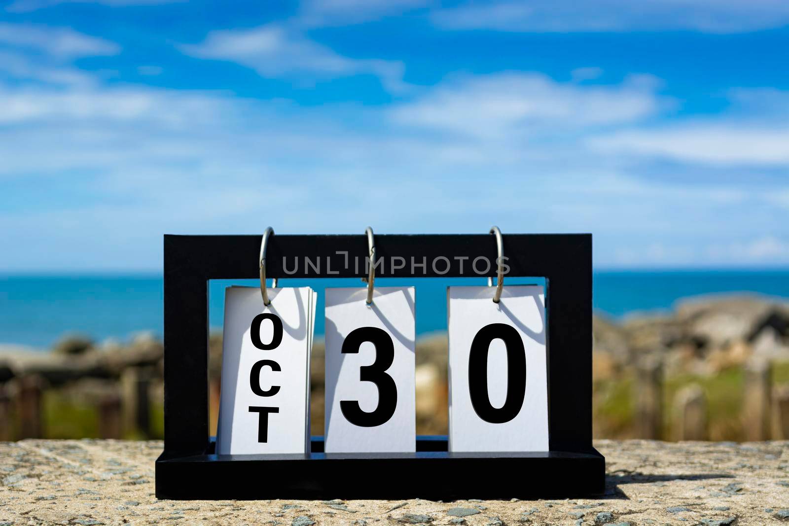 Oct 30 calendar date text on wooden frame with blurred background of ocean. Calendar date concept.