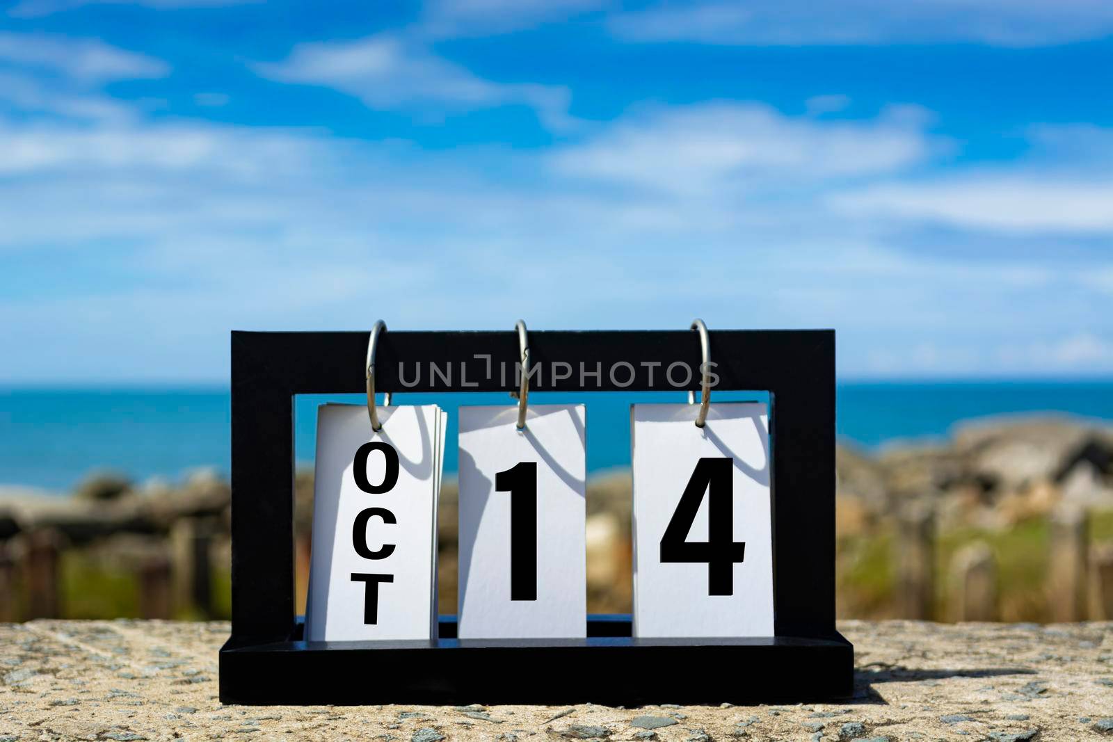 Oct 14 calendar date text on wooden frame with blurred background of ocean. Calendar date concept.