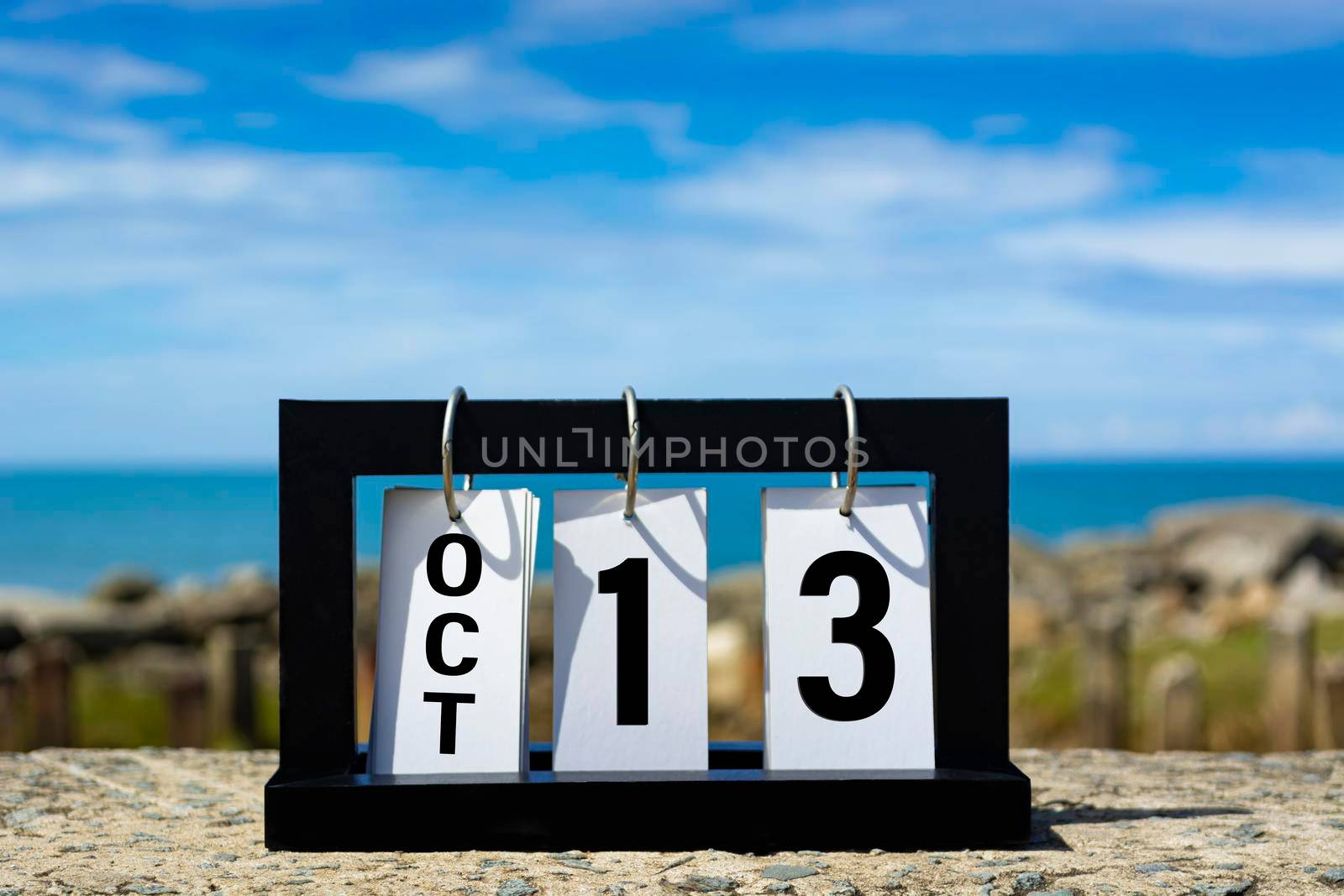 Oct 13 calendar date text on wooden frame with blurred background of ocean. Calendar date concept.