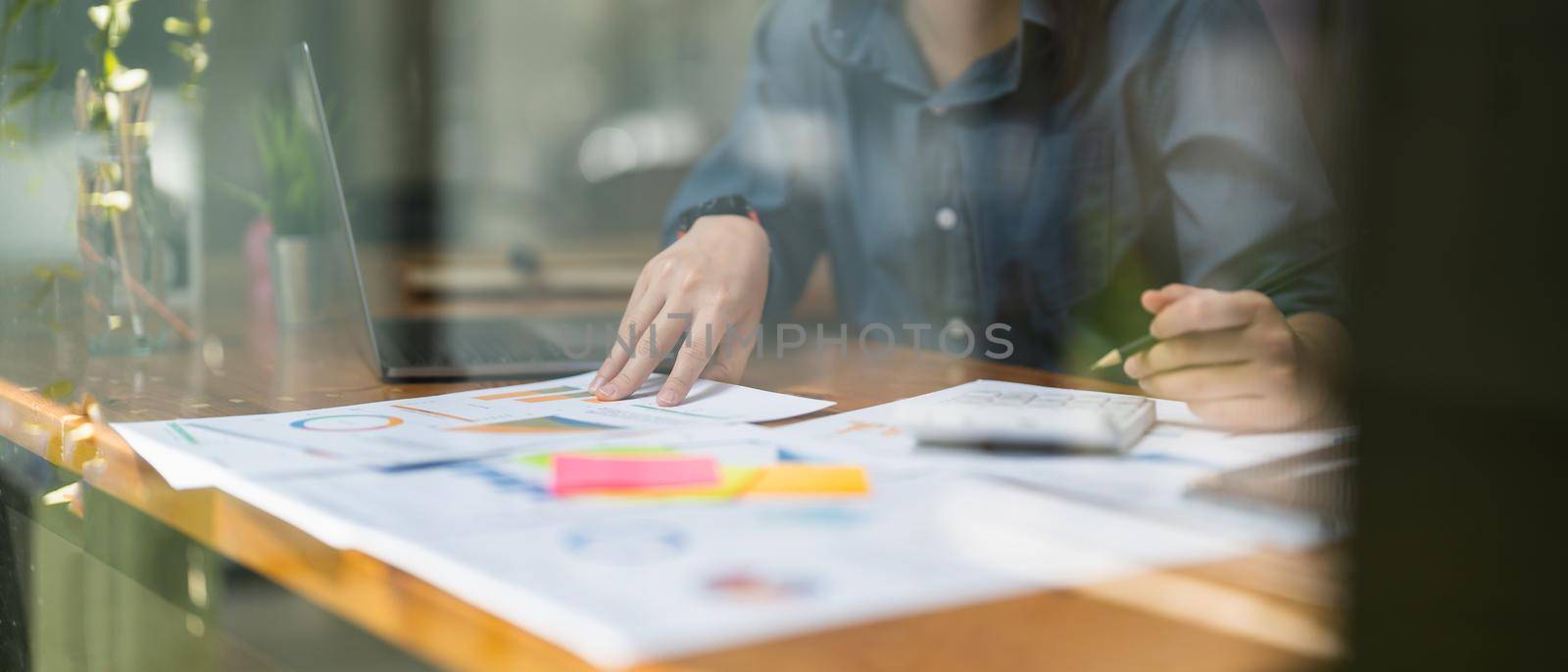 businesswoman working on desk office with using a calculator to calculate the numbers, finance accounting concept.