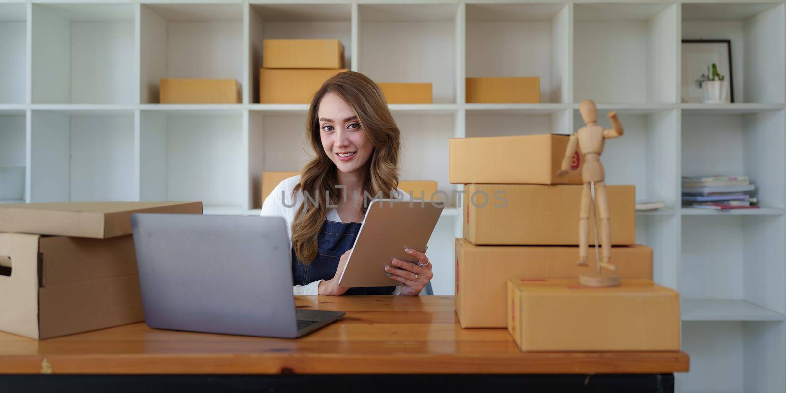 Attractive Asian SME business woman working at home office. online shopping concept.