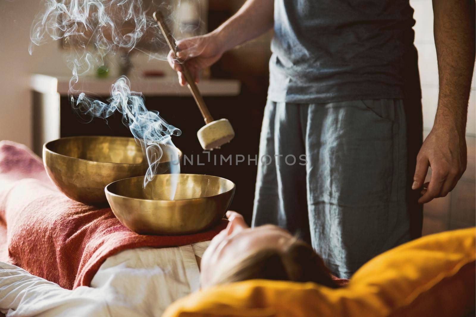 Tibetan singing bowls with smoke in sound therapy in spa center by Mariakray