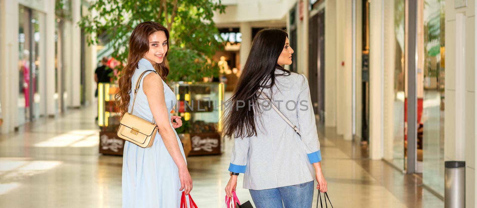 Two women walking in shopping mall by okskukuruza