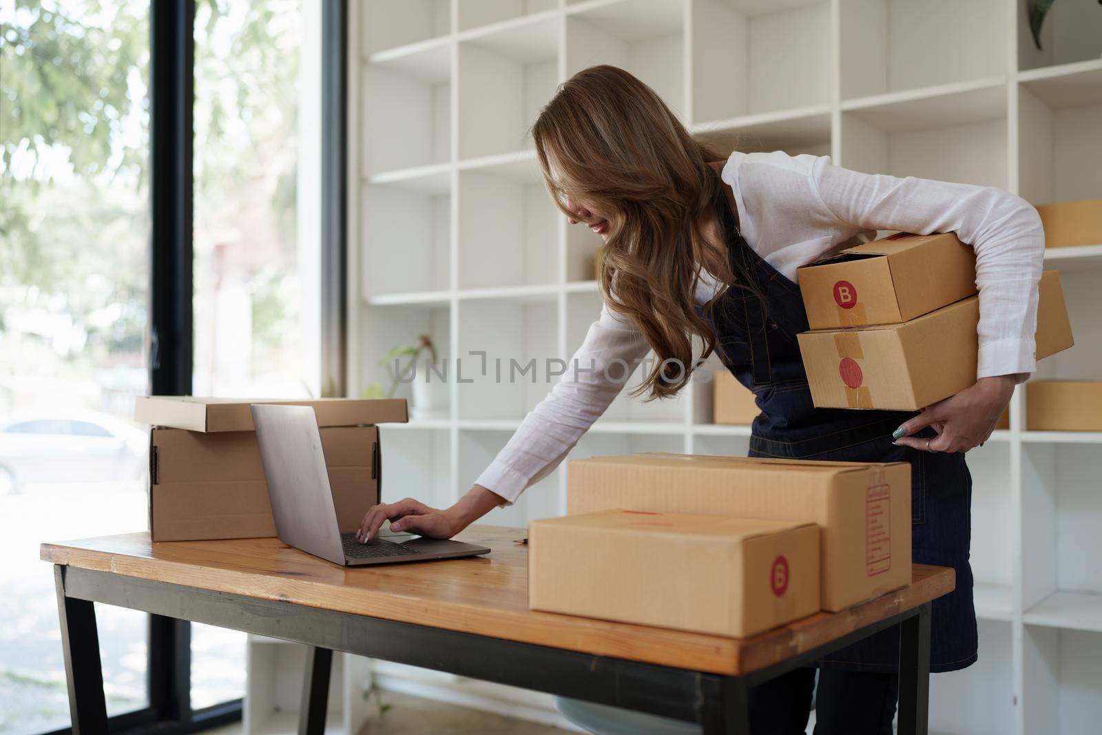 Attractive Asian SME business woman working at home office. online shopping concept.