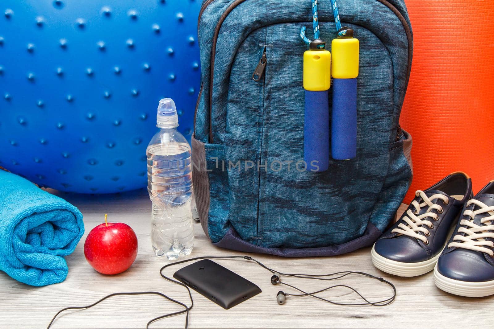 Backpack and different tools for fitness on floor in room by mvg6894