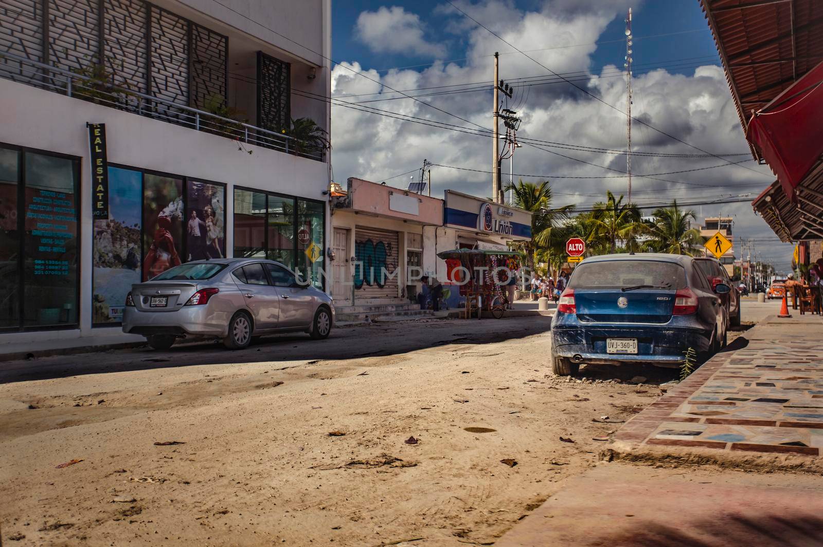 Tulum, Mexico 20 august 2022: View of a street of Tulum in Mexico with unpaved roads and some vehicles parked at the side