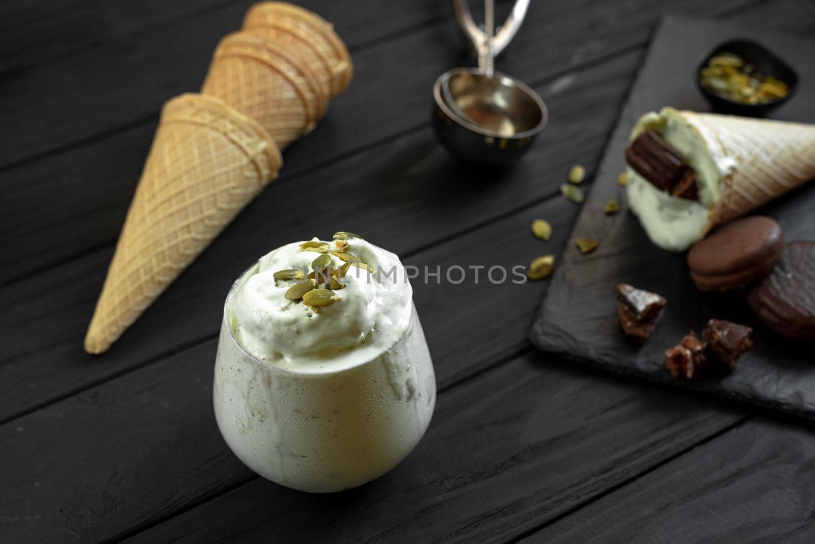 Homemade pistachio ice cream on a dark background. Ingredients for making ice cream on a wooden background.