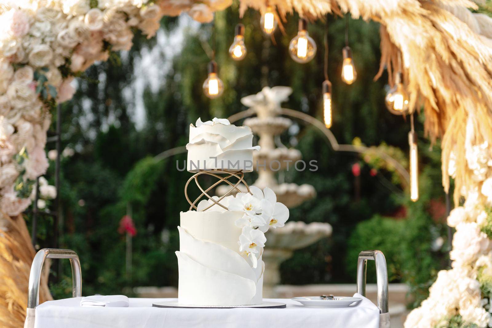 Wedding cake on the background of the wedding arch