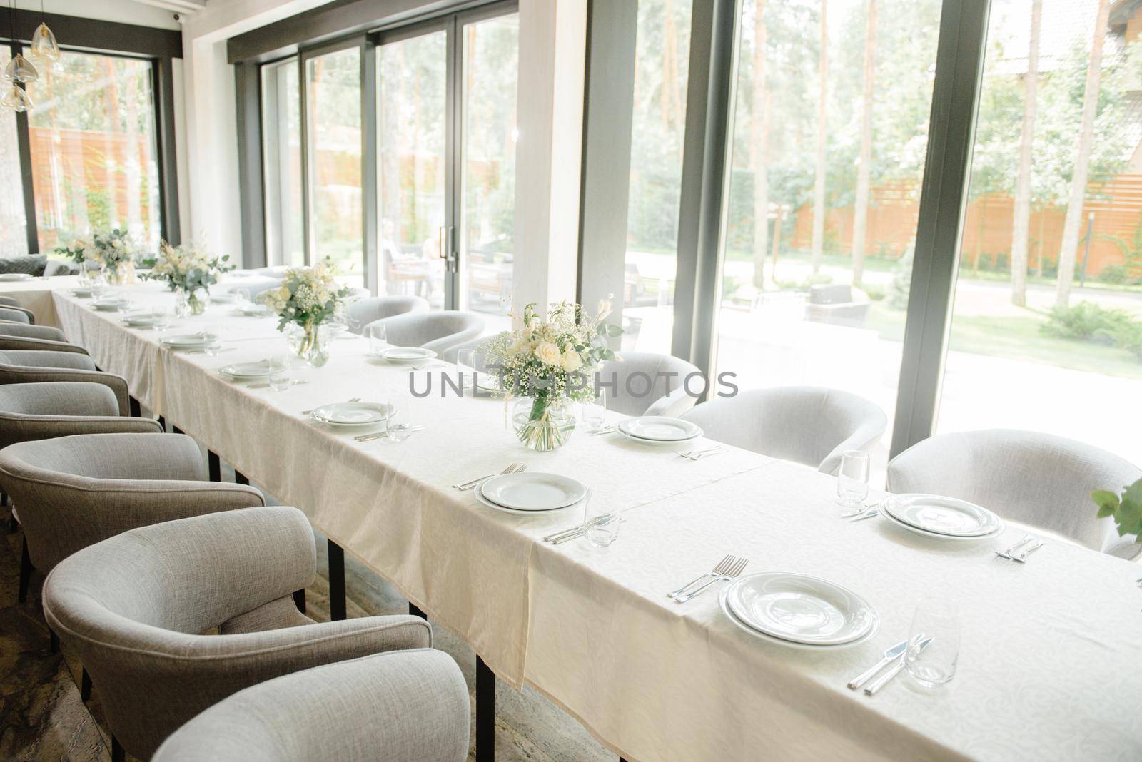 Wedding reception table in the restaurant decorated with white candles and flowers