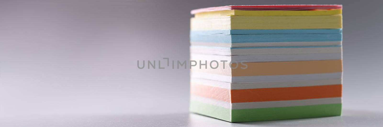 Close-up of perfect stack of colourful paper for notes, set of sticky post it notes. Bright office pages for reminder or ideas writing. Stationery concept