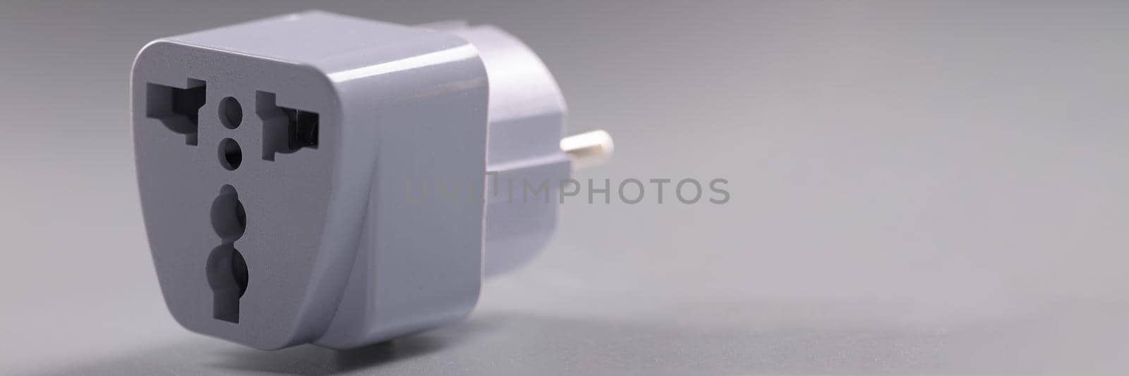 Close-up of universal white plugs adapter, adapter to put in sockets. Multi plug travel size power adapter. Charge, energy, electricity, connector concept