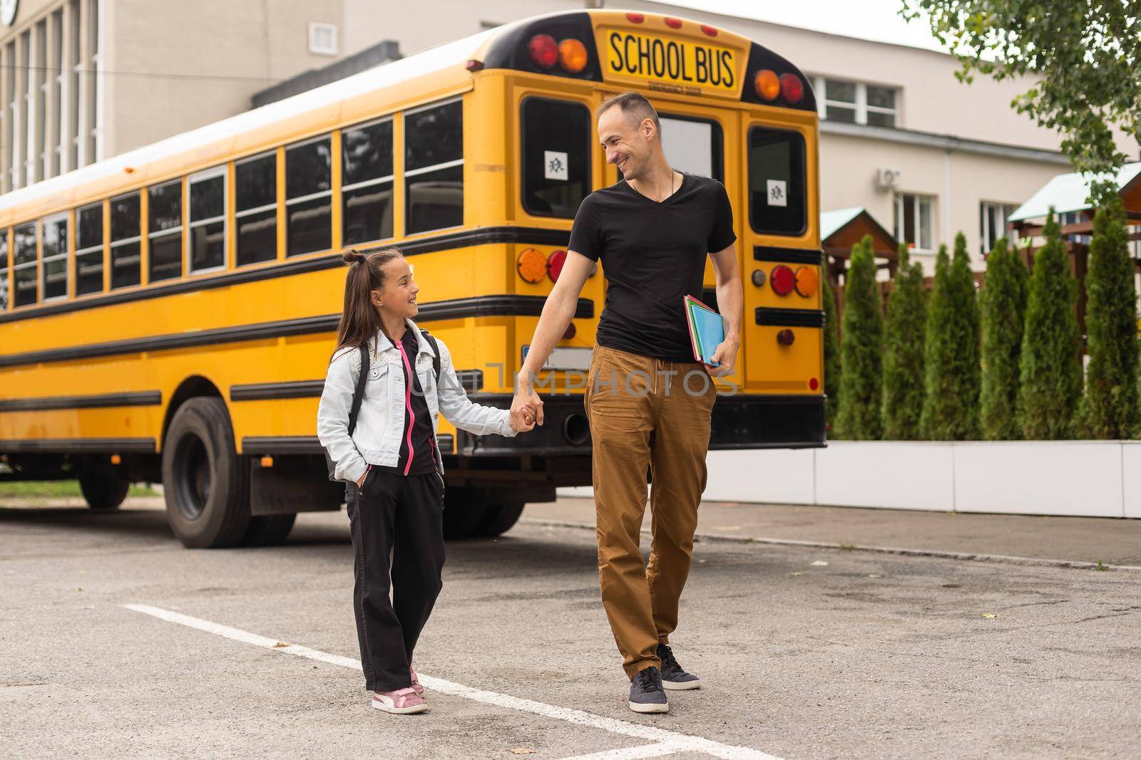 Parent taking child to school. Pupil of primary school go study with backpack outdoors. Father and son go hand in hand. Beginning of lessons. Back to school. First day of fall. Elementary student.