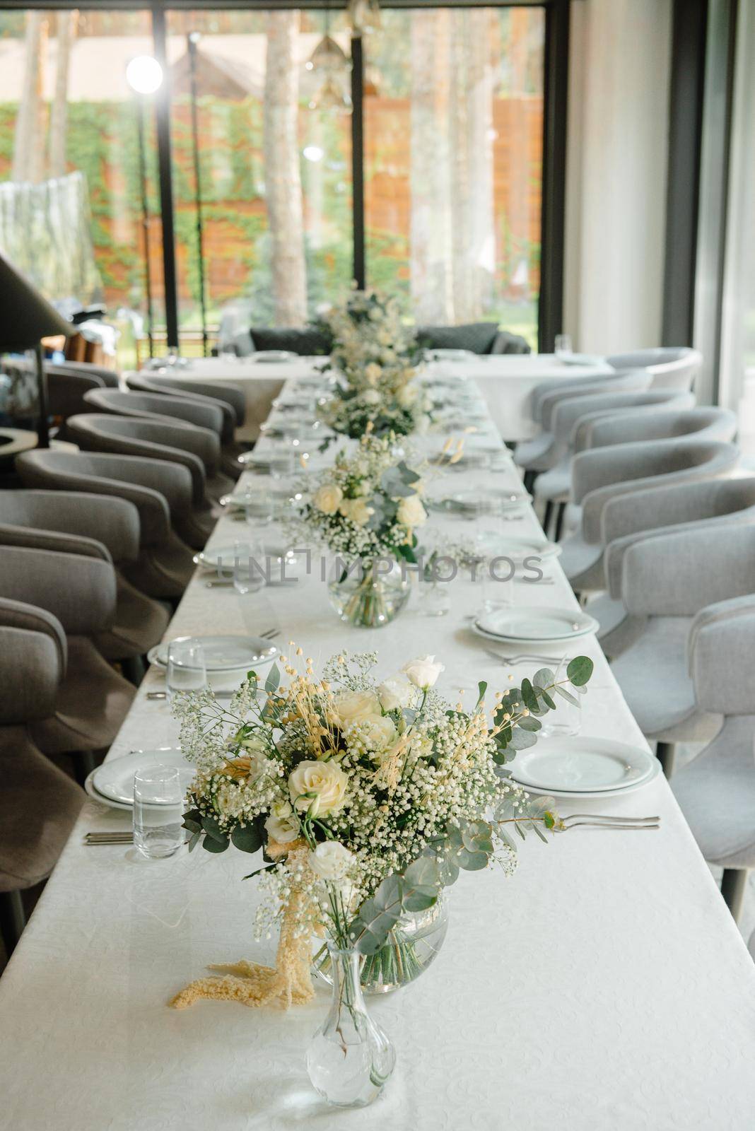 Wedding reception table in the restaurant decorated with white candles and flowers