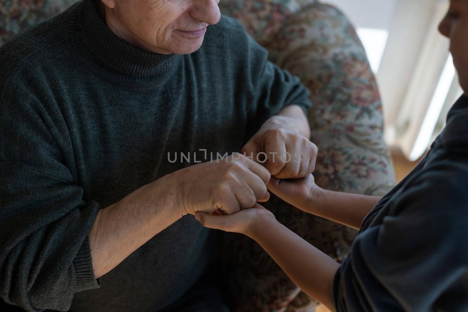 grandfather and granddaughter hands close up.