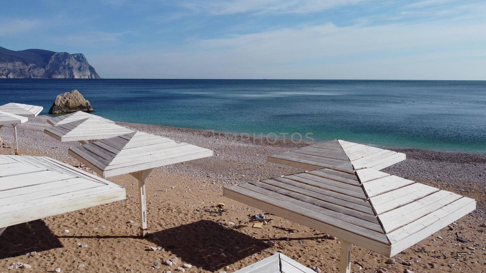 Aerial view from above on azure sea and pink pebbles beach. Small waves on cristal clear water surface in motion blur. Summer ocean sea beach background. Nobody. Holiday, vacation and travel concept by panophotograph