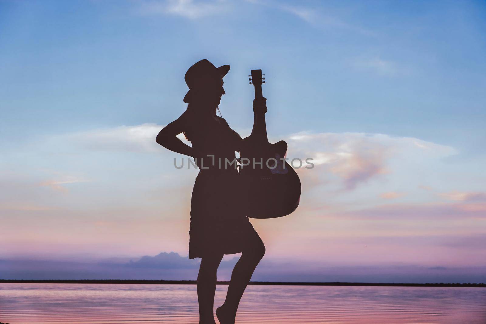Photo of happy woman with acoustic guitar overjoyed isolated vibrant blue sunset color background by igor010