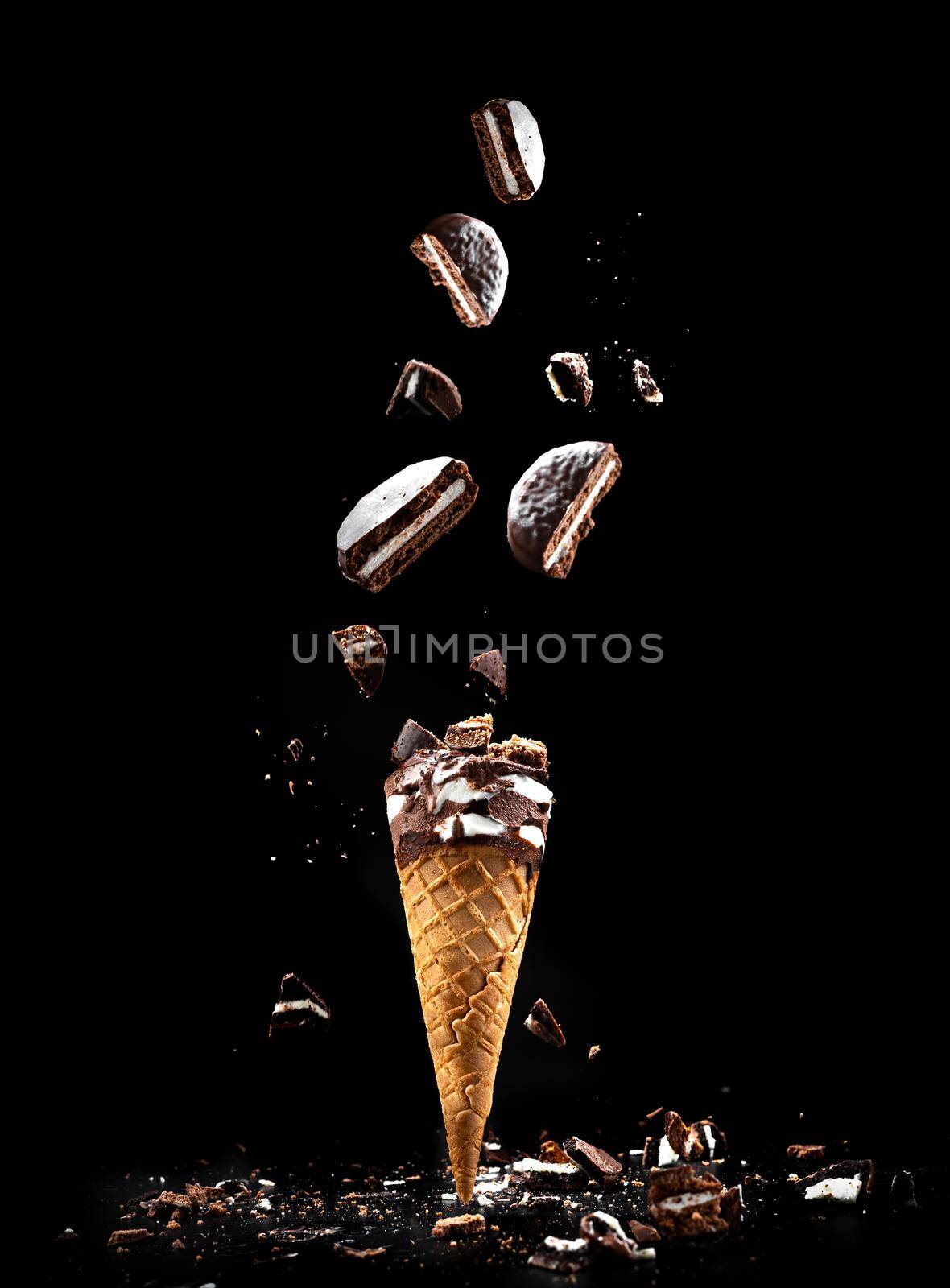 Cookies N' Cream ice cream on a black background in a waffle cup. Ice cream with cookies levitation and flying