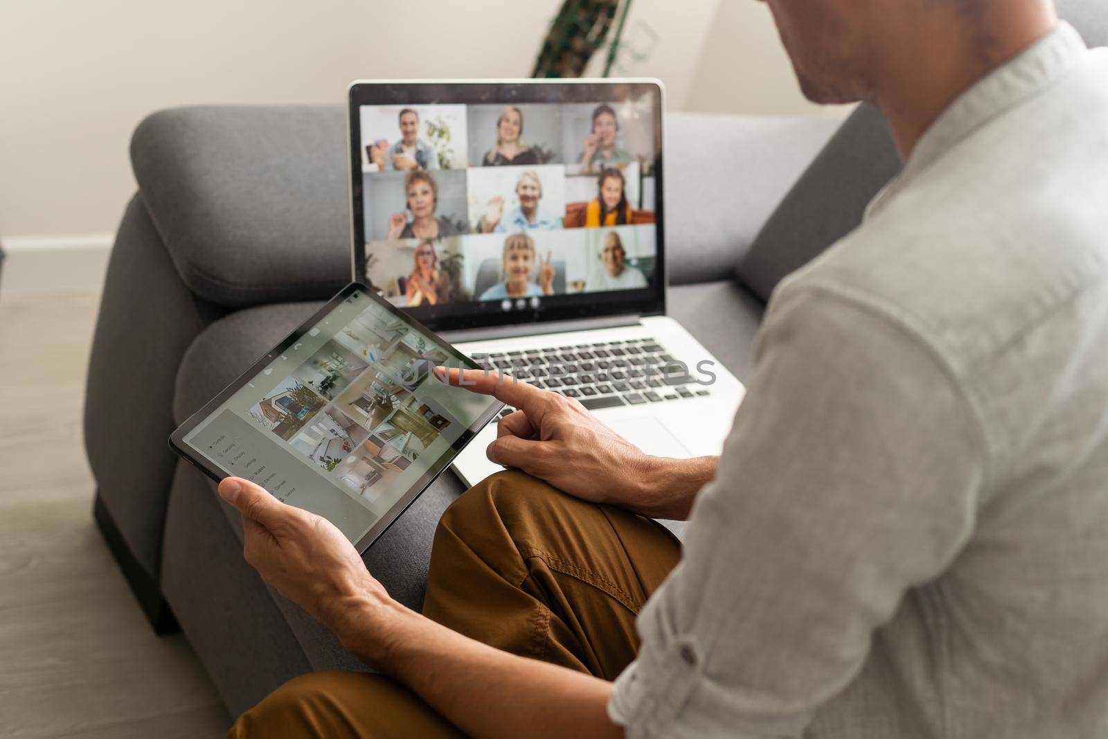 man working from home use Smart working and video conference online meeting with team using laptop and tablet online in video call for new projects.