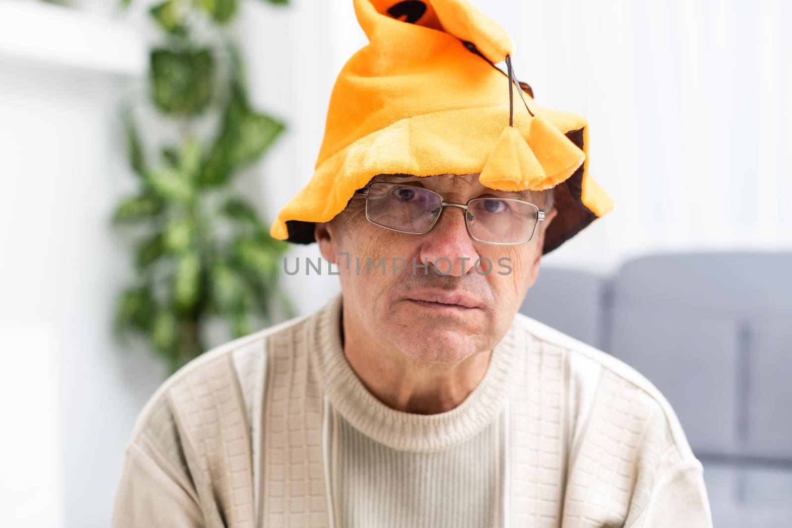 elderly sad man celebrating halloween at home