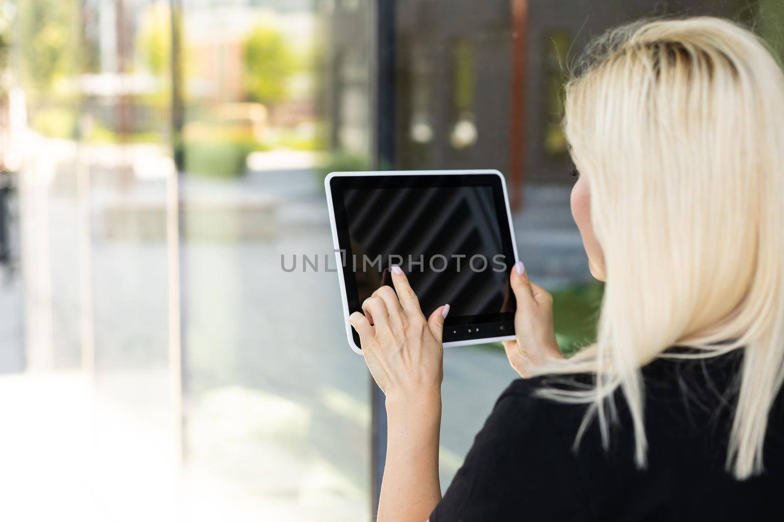 young caucasian woman sitting in city, holding tablet - technology, social network, communication concept.