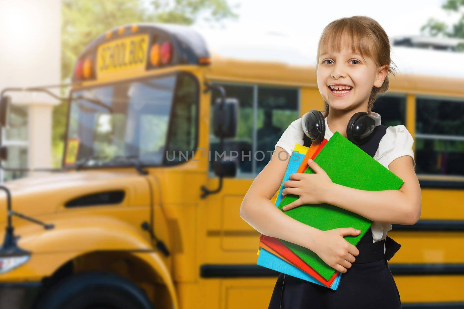 Smiling active excellent best student schoolgirl holding books and going to school wearing bag by Andelov13