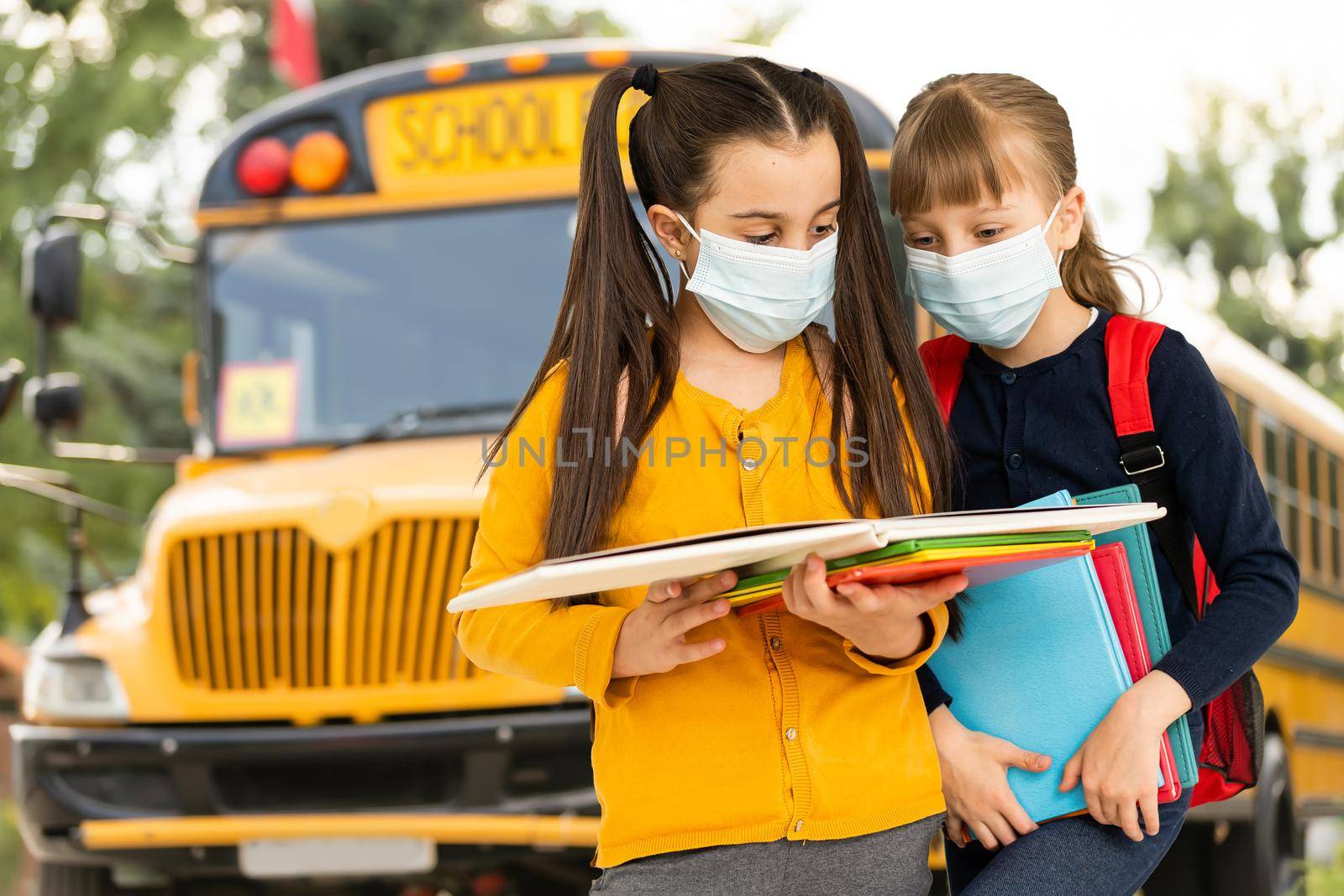 Children wearing face protective mask going back to school during corona virus pandemic. Healthcare and education concept.