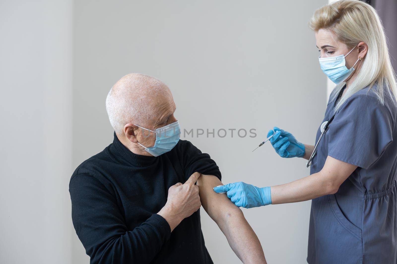 Booster Coronavirus. A syringe in the hands of a doctor injecting the covid-19 coronavirus vaccine to a man.