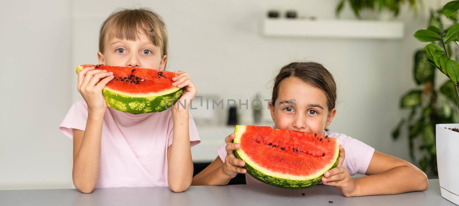 Two girls eating Watermelon isolated at home by Andelov13