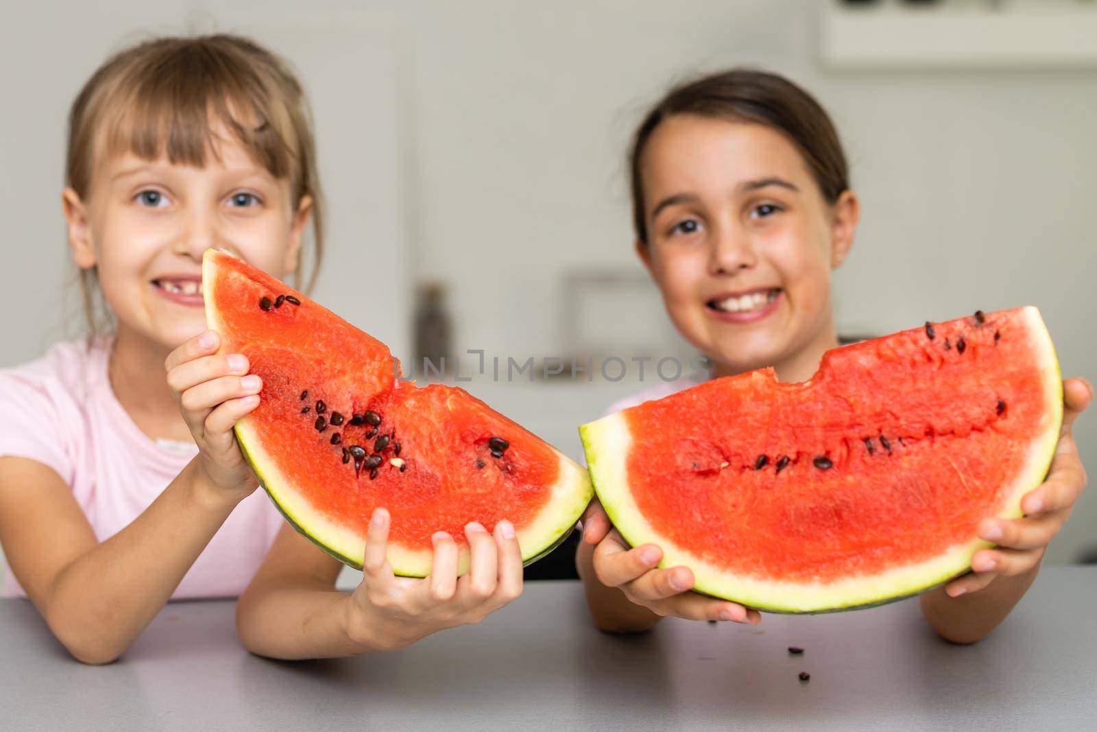 Two girls eating Watermelon isolated at home.