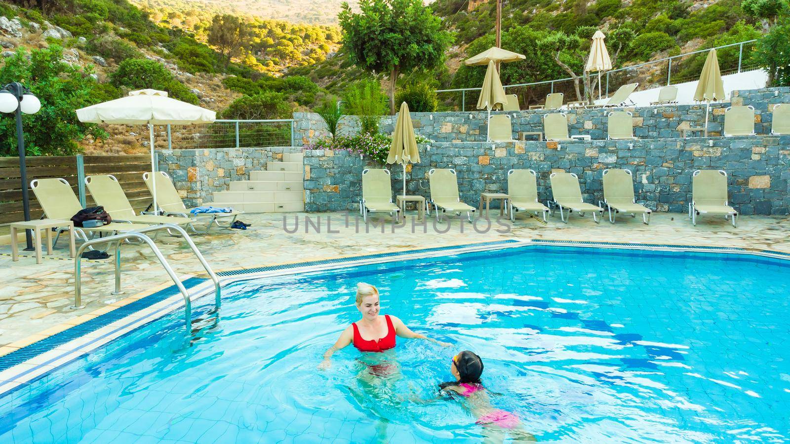 mother and daughter playing in a swimming pool.