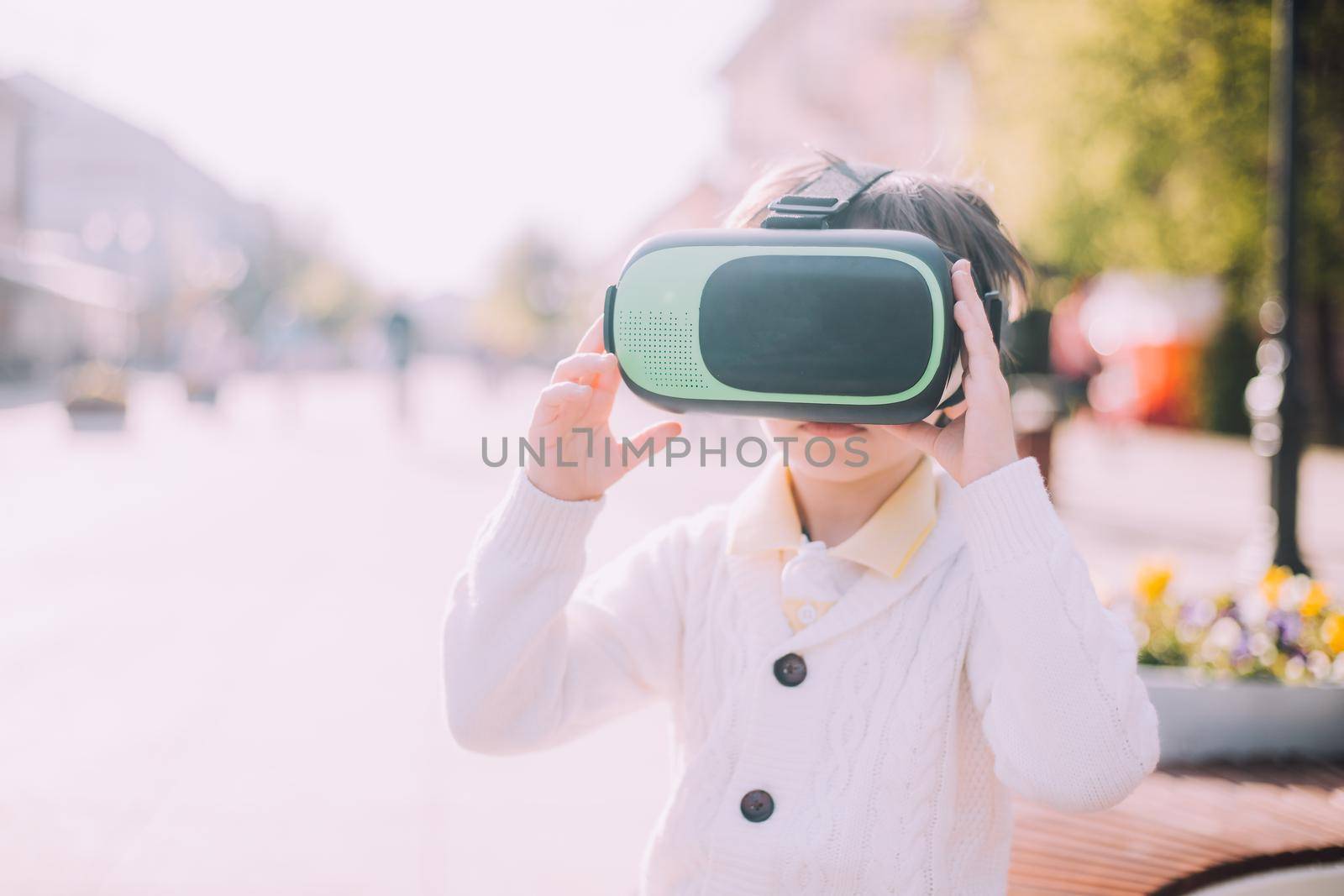 A boy is playing virtual reality glasses on the street . Modern gadgets. Children's games. The choice of virtual glasses. An article about virtual glasses. Modern children. by alenka2194