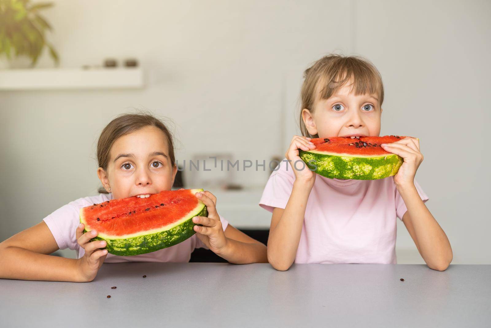 Two girls eating Watermelon isolated at home.