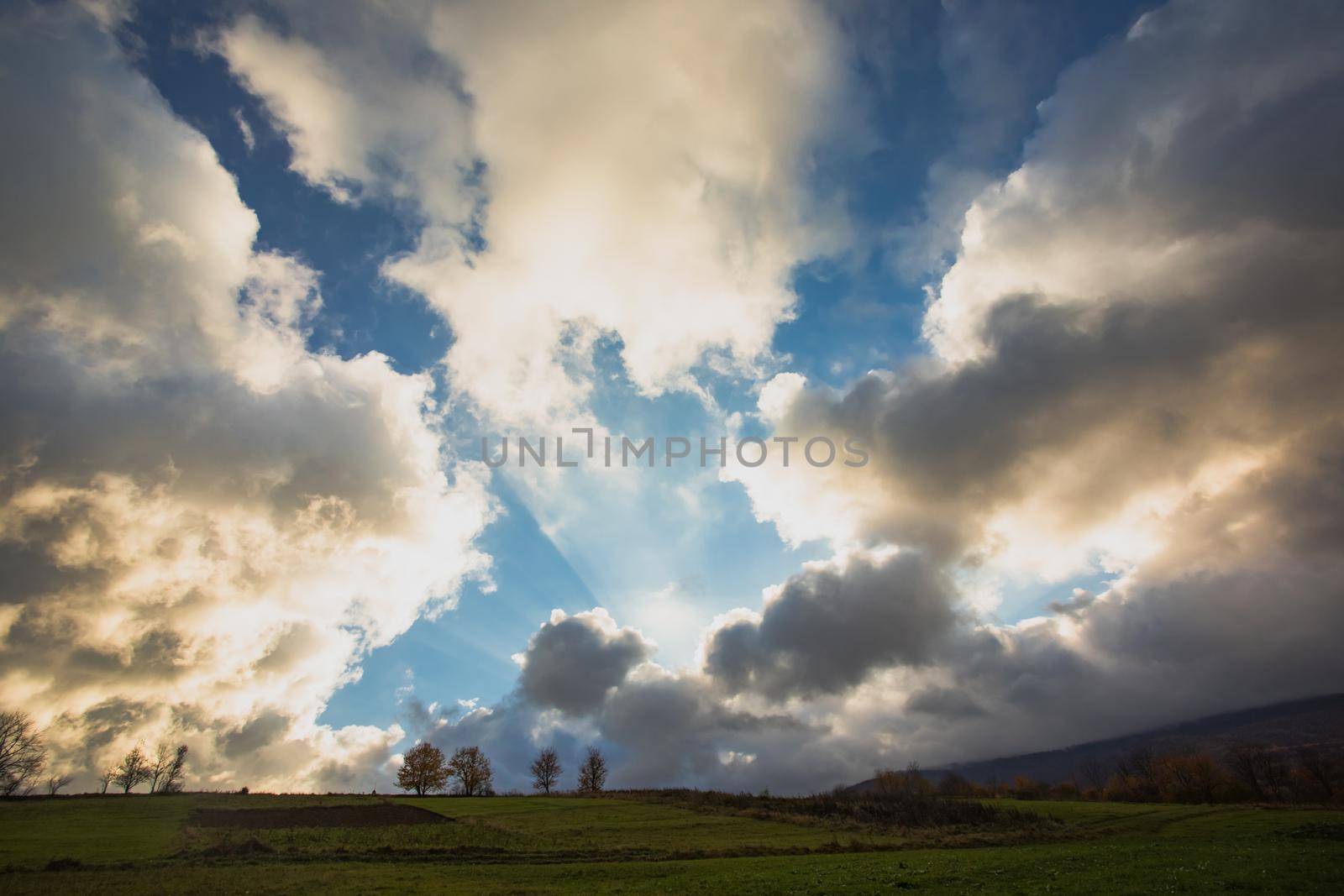 The sun magically shines through the cloud producing amazing sun ray in the sky