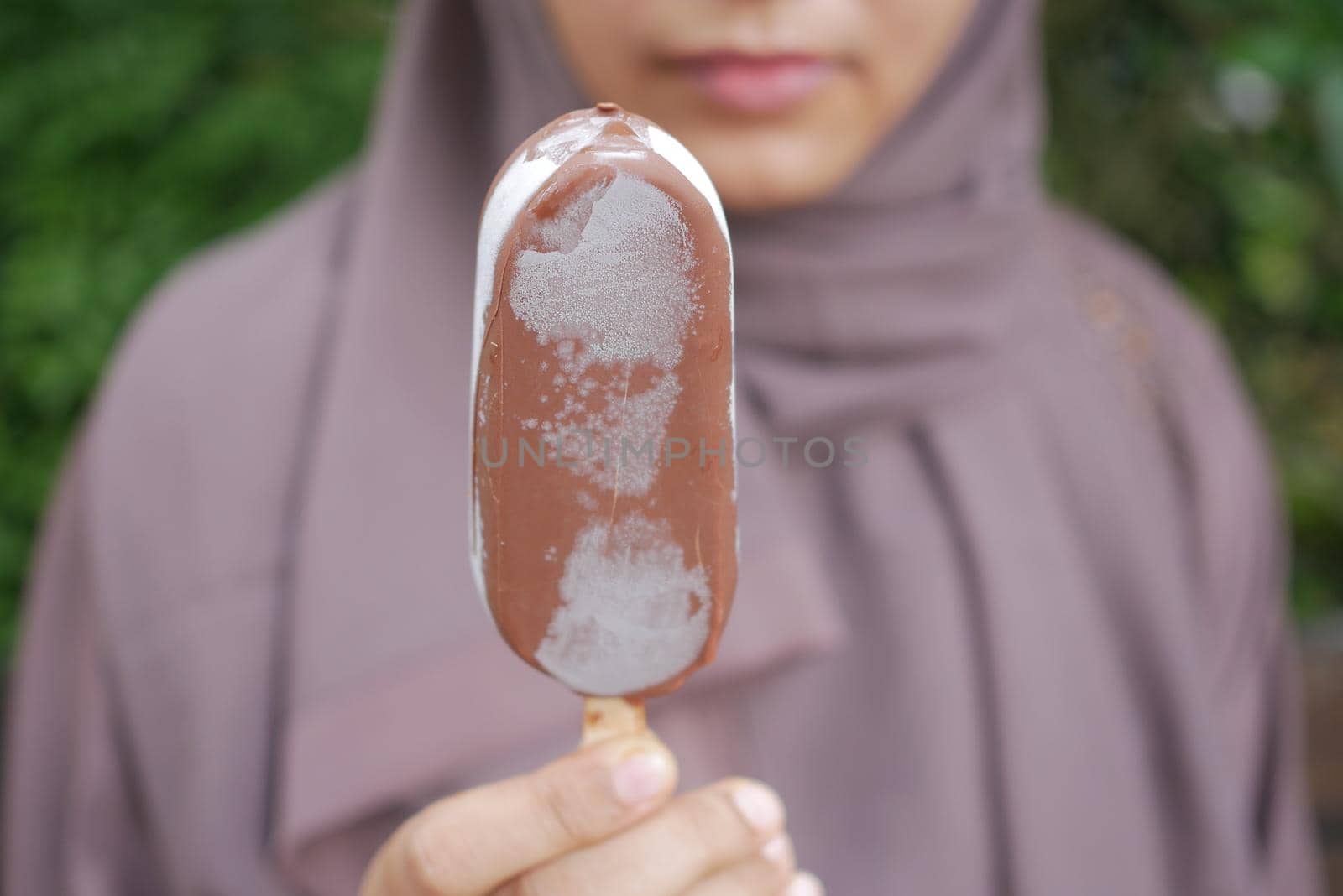 young women eating chocolate flavor ice cream .