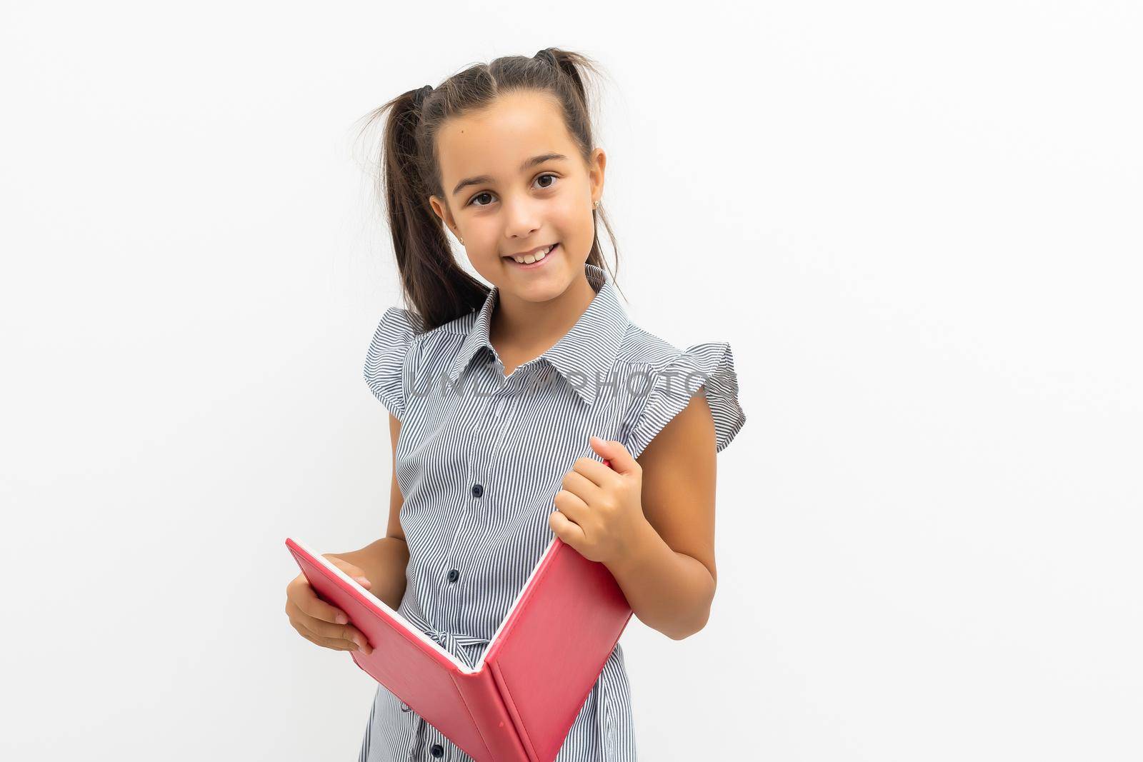 Little girl holding a big book. Isolated on white background.