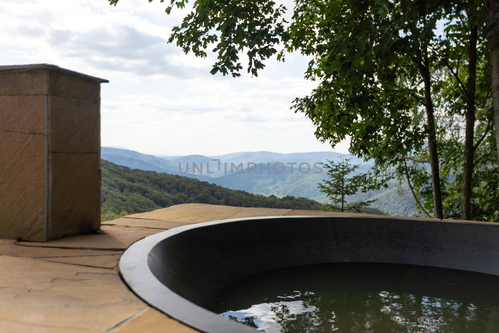 Wooden hot vat on terrace at mountains. vacation concept with hot bath outside. summer.
