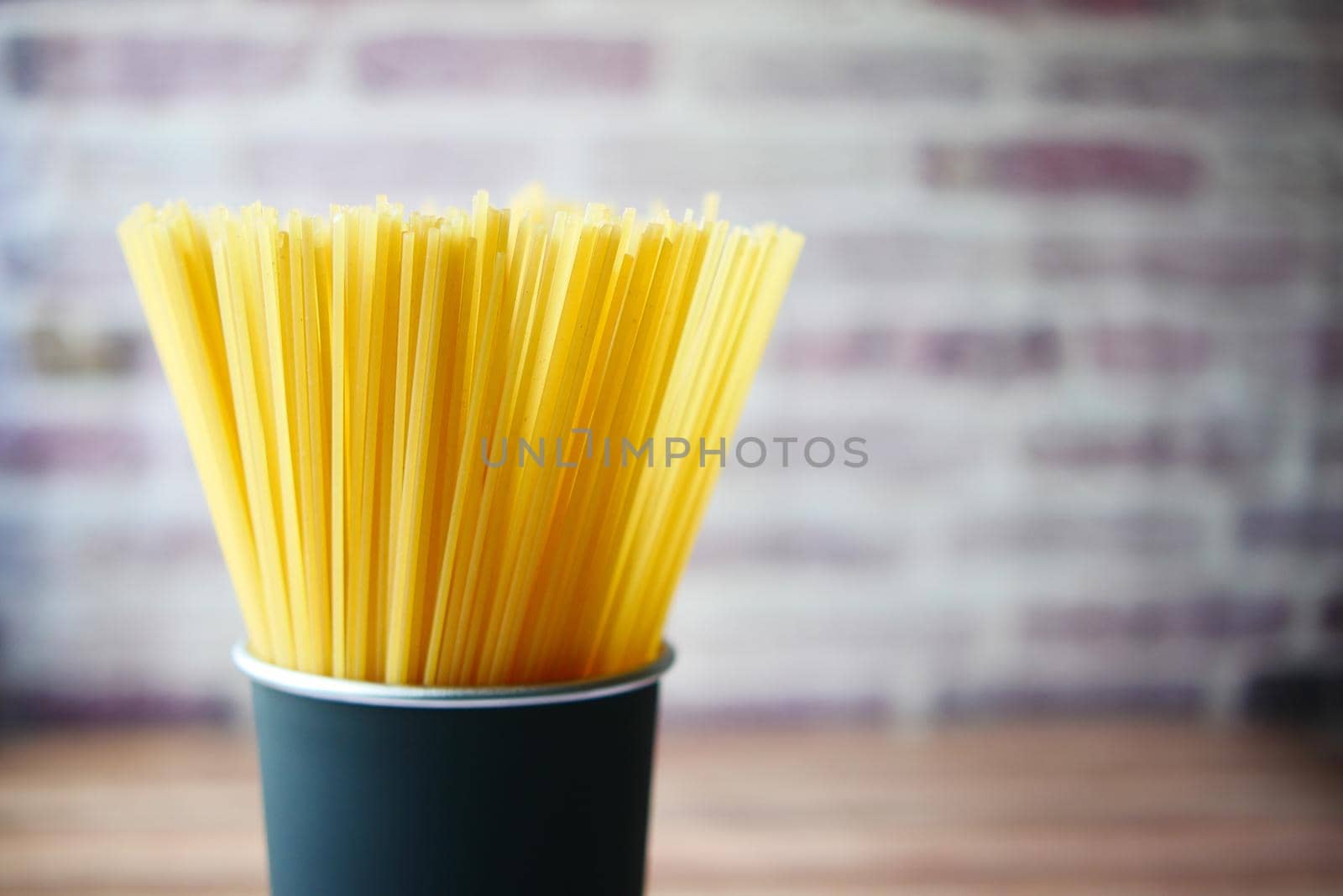 Yellow long spaghetti in a container on table ,