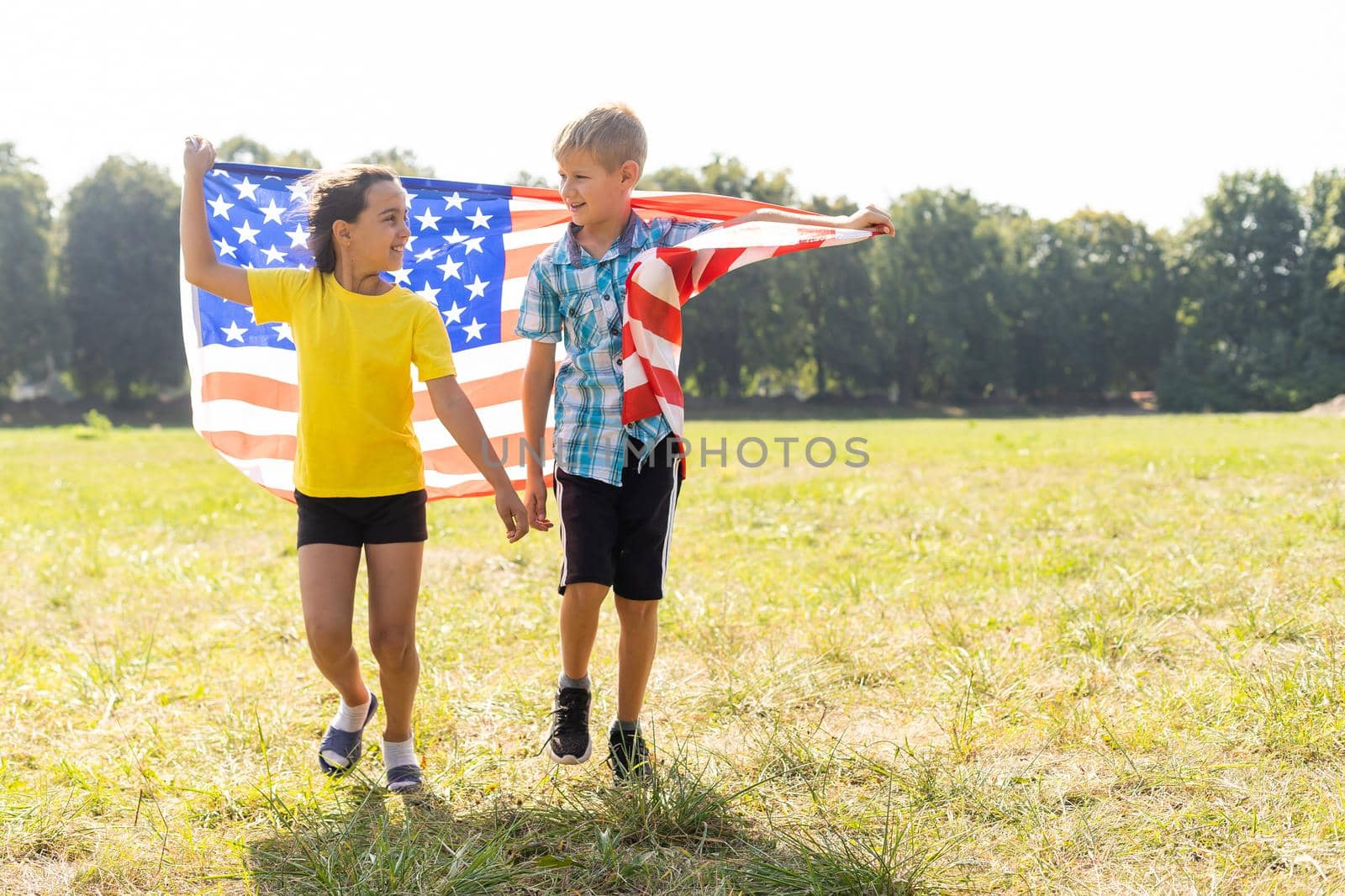 Children sit with American flag outdoors