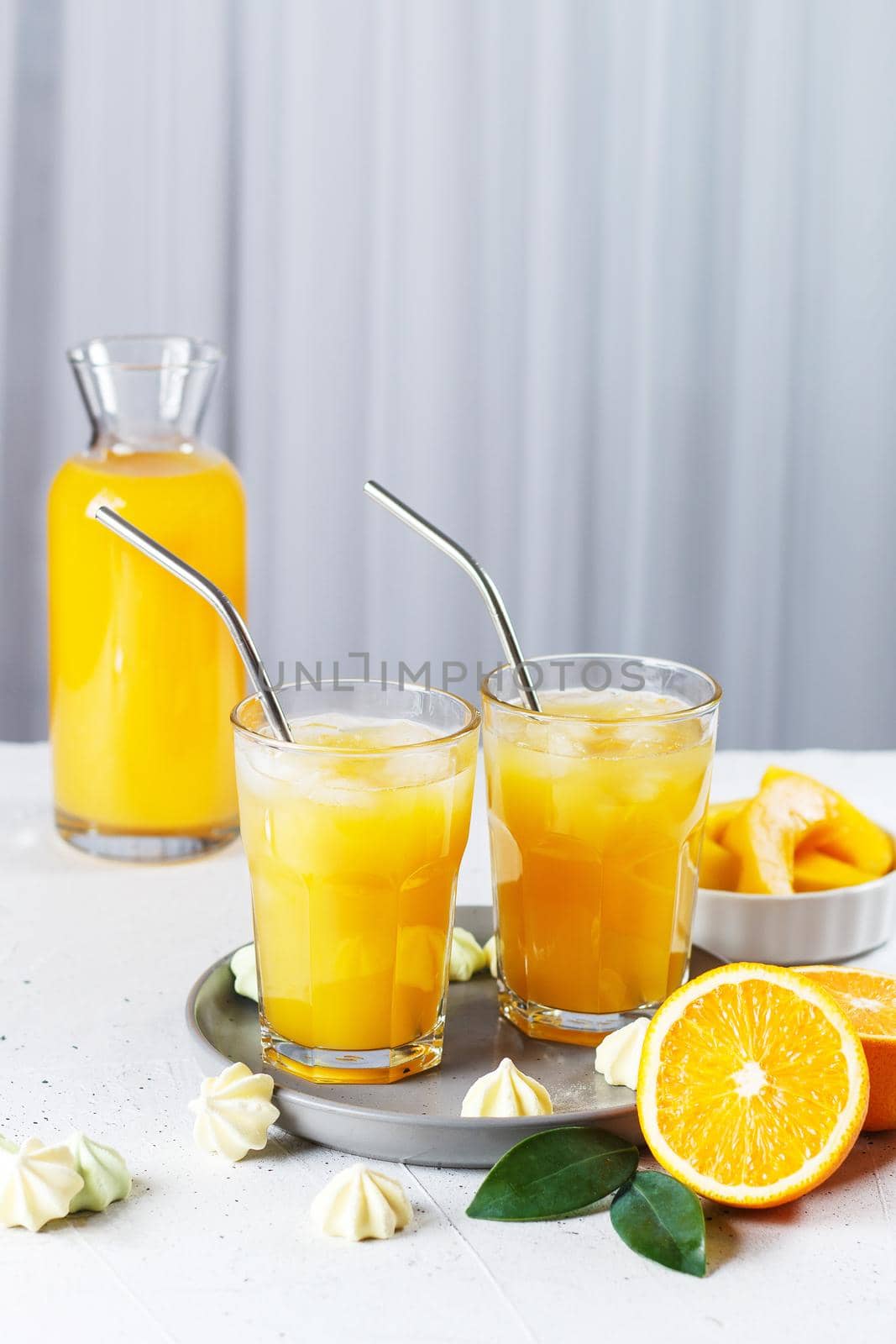 Glasses with orange juice, orange slices and mango on a gray background. by lara29