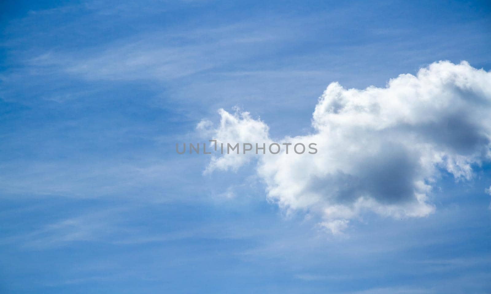 Summer sky. Cumulus clouds on a blue background. Partly cloudy. Dark clouds and white clouds.