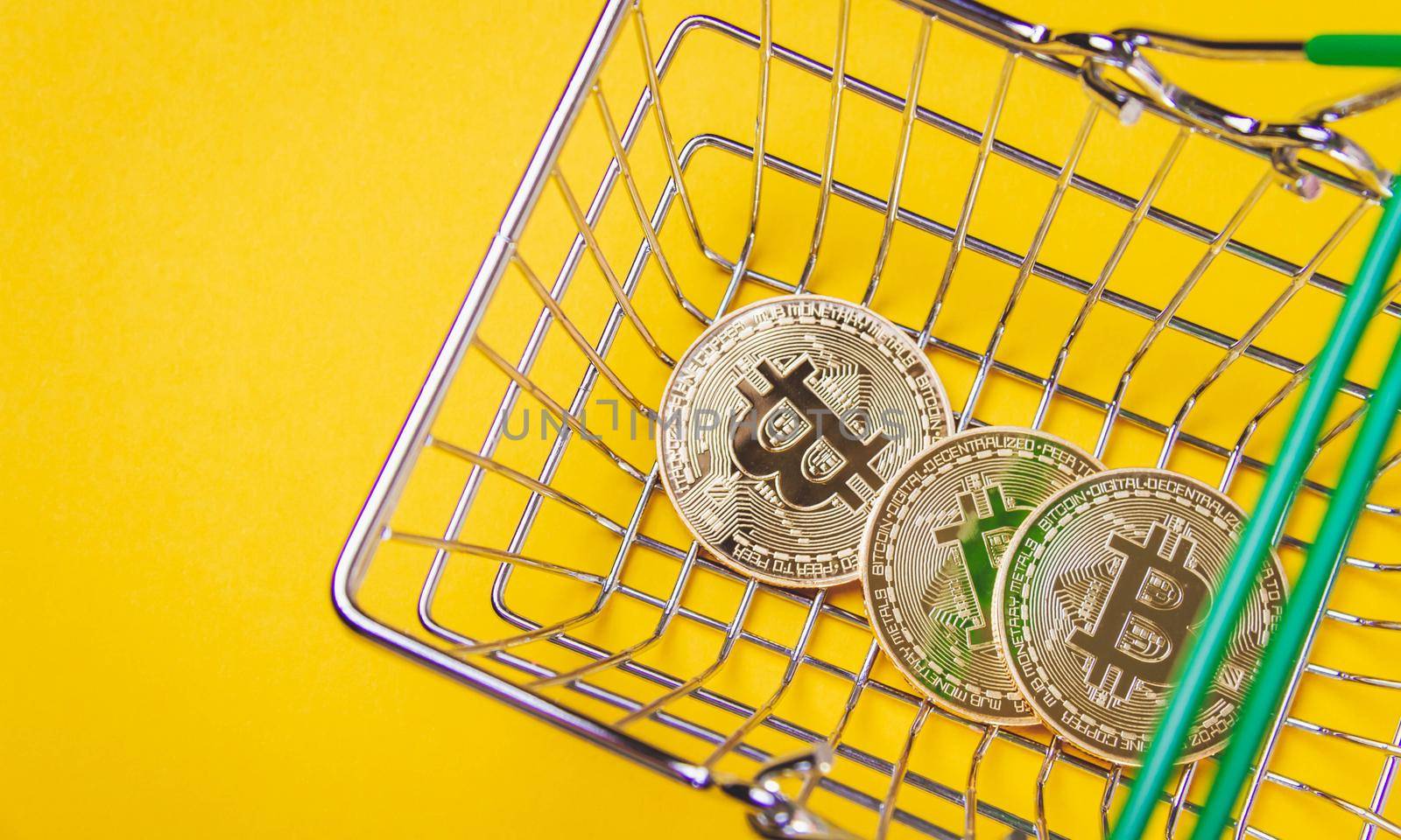 Bitcoin in a shopping cart. Buying and paying with cryptocurrencies. Currency exchange.